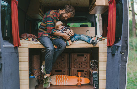 Campen mit Kind – Vater und Sohn spielen im Wohnmobil. Campen mit Kind – Vater und Sohn spielen im Wohnmobil.