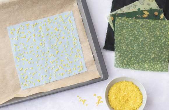 Instructions on beeswax wraps: pieces of fabric with beeswax on a baking tray.