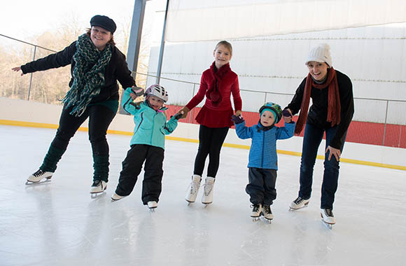 Familie beim Schlittschuhlaufen in der Eishalle. Familie beim Schlittschuhlaufen in der Eishalle.
