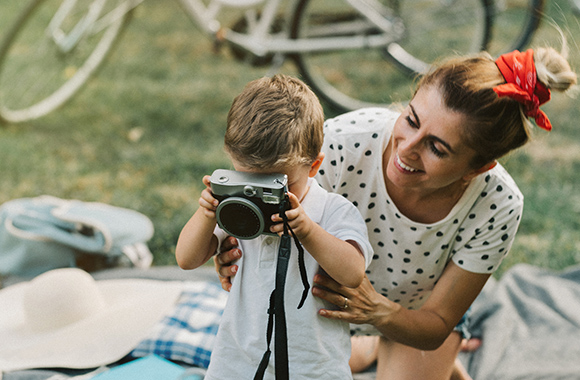 Appareil numérique et enfant : un garçon apprend à photographier avec sa maman.