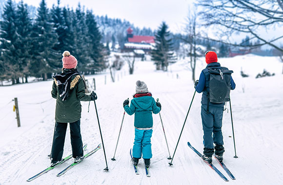 Une famille profitant des paysages lors de leur promenade en ski nordique.