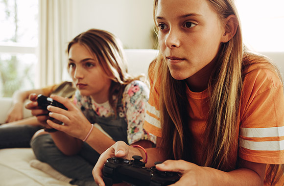 Due bambine giocano insieme con una console