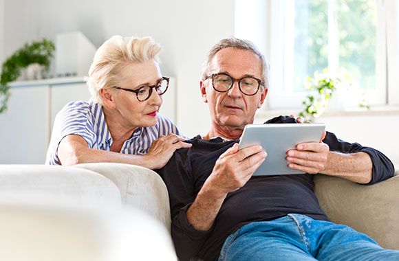 Bejaarde echtpaar kijken samen naar een tablet. Bejaarde echtpaar kijken samen naar een tablet.