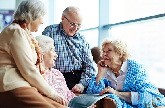Senioren sitzen gemeinsam auf einem Sofa und unterhalten sich. Senioren sitzen gemeinsam auf einem Sofa und unterhalten sich.