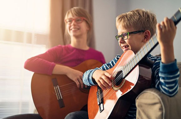 Strumenti musicali per bambini – Una lezione di gruppo di chitarra.