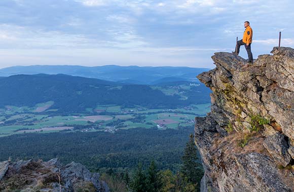 Goldsteig wandern – Wanderer genießt die Aussicht vom Kaitersberg. Goldsteig wandern – Wanderer genießt die Aussicht vom Kaitersberg.