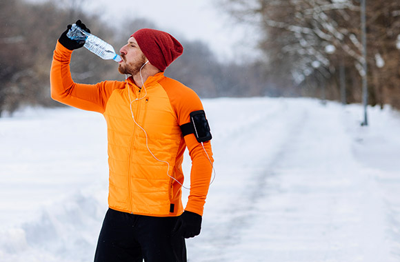 Joggen in de winter: Hardloper neemt een pauze en drinkt water.