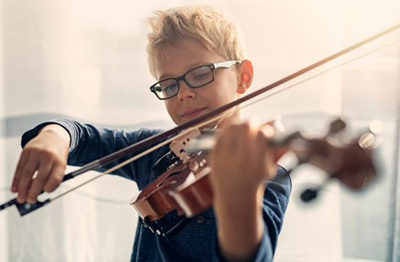 Hobby’s voor kinderen bevorderen de ontwikkeling – jongen speelt viool.