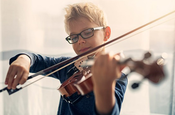 Hobby’s voor kinderen bevorderen de ontwikkeling – jongen speelt viool. Hobby’s voor kinderen bevorderen de ontwikkeling – jongen speelt viool.