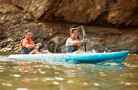 Due sportivi percorrono un fiume in kayak. Due sportivi percorrono un fiume in kayak.