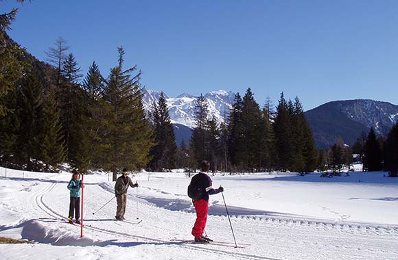 Drei Langläufer vor Bergkette. Drei Langläufer vor Bergkette.