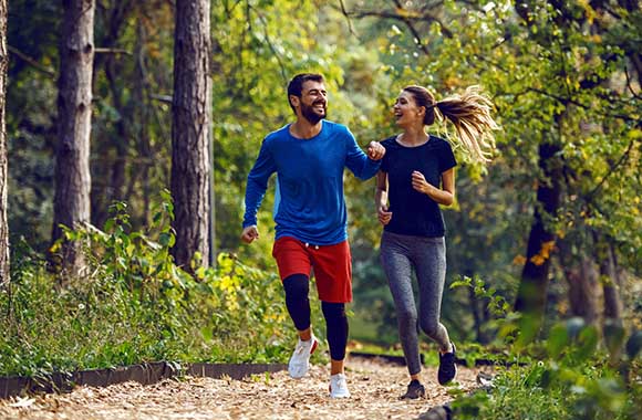 Improving your running technique - friends jogging together in the forest.