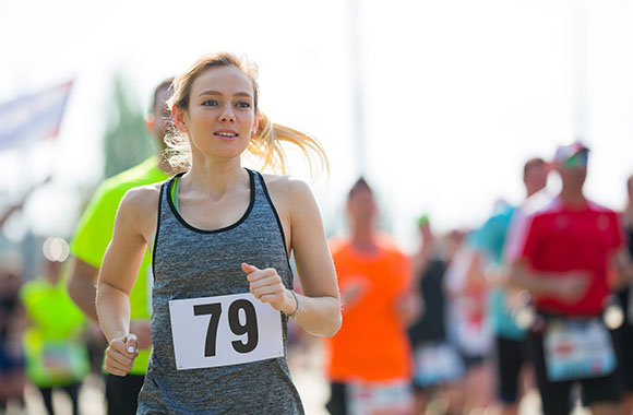 Running training goal: Woman taking part in a race.