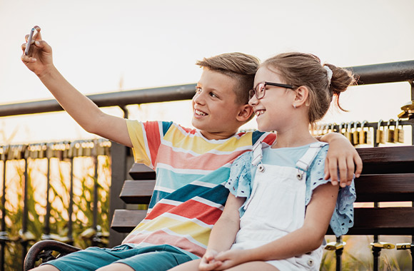Uso dei social media – Due bambini fanno un selfie insieme.