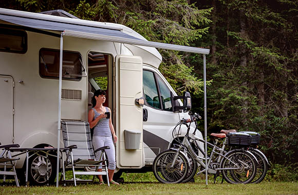 Jonge vrouw drinkt thee voor haar camper. Jonge vrouw drinkt thee voor haar camper.