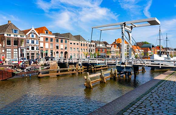 Fietsen in Zwolle – Via een brug de gracht oversteken. Fietsen in Zwolle – Via een brug de gracht oversteken.