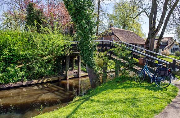 Fietsen in Overijssel – Fietsen over de bruggetjes in Giethoorn. Fietsen in Overijssel – Fietsen over de bruggetjes in Giethoorn.