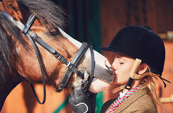 Meisje kust een paard bij de paardrijles. Meisje kust een paard bij de paardrijles.