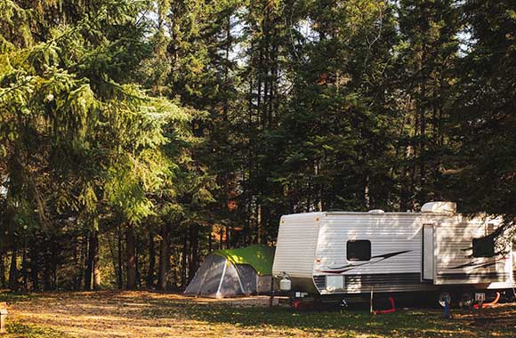 Kamperen in de natuur – Camper en tentje in het bos. Kamperen in de natuur – Camper en tentje in het bos.