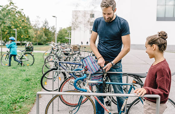 Dziecko na rowerze – Tata towarzyszy córce na rowerze podczas drogi do szkoły