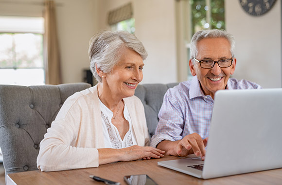 Älteres Paar stöbert gemeinsam in einem Online-Shop.