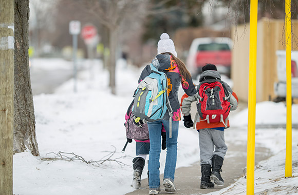 Des écoliers marchent dans la neige sur le chemin de l’école Des écoliers marchent dans la neige sur le chemin de l’école