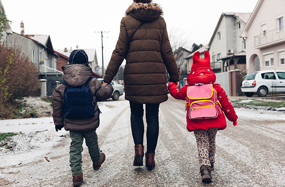 Une mère accompagne ses enfants à l’école Une mère accompagne ses enfants à l’école