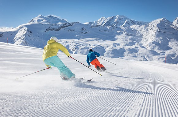 Zwei Skifahrer auf einer Skipiste.