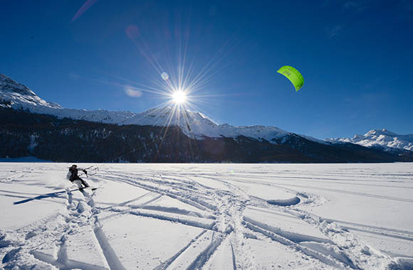 Mann wird von Snowkite über verschneite Ebene gezogen. Mann wird von Snowkite über verschneite Ebene gezogen.