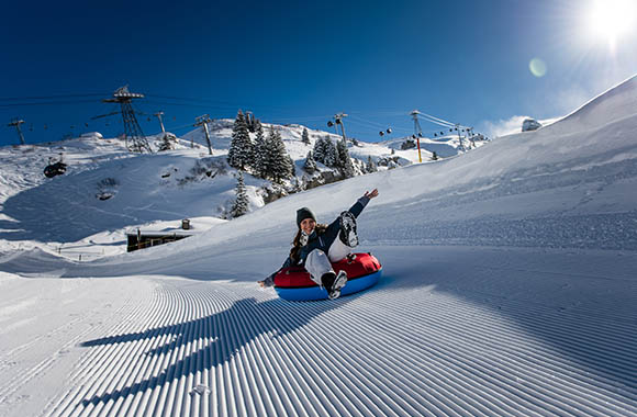 Frau fährt auf einem Snowtube eine Schneepiste hinab. Frau fährt auf einem Snowtube eine Schneepiste hinab.