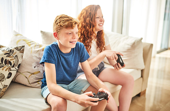 Deux enfants en train de jouer sur une console de jeu Deux enfants en train de jouer sur une console de jeu