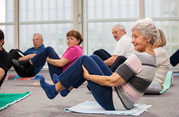 Des retraités pratiquant la gym douce durant un cours.