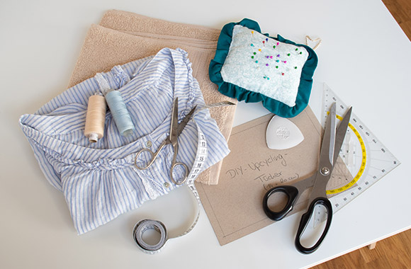 Tools needed for sewing DIY cloths - fabric, scissors, thread, tape measure and a ruler.