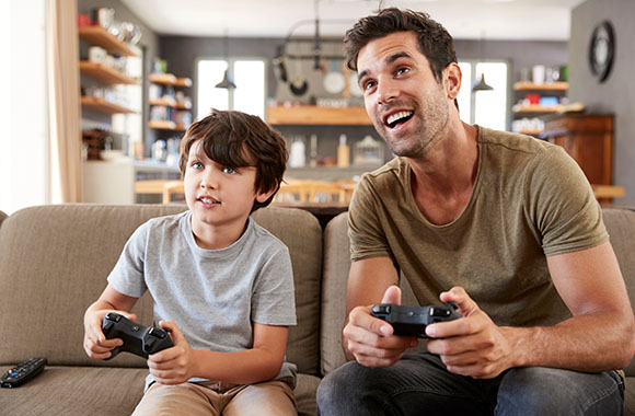 Leeftijdsclassificatie – Vader en zoon spelen samen een geschikte videogame voor kinderen. Leeftijdsclassificatie – Vader en zoon spelen samen een geschikte videogame voor kinderen.
