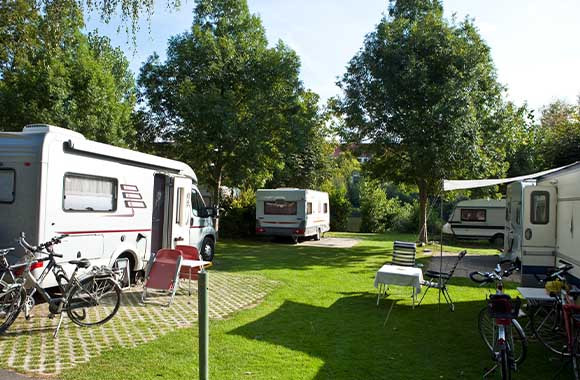 Campingregels: geparkeerde caravans en campers met campingmeubels en fietsen. Campingregels: geparkeerde caravans en campers met campingmeubels en fietsen.