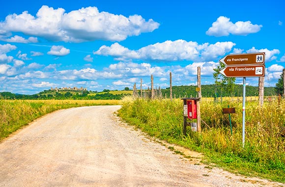 Cammini italiani - Cartelli stradali metallici indicano il sentiero per la Via Francigena. Cammini italiani - Cartelli stradali metallici indicano il sentiero per la Via Francigena.