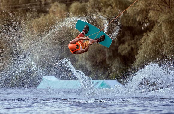Un wakeboarder fait un saut à l’aide d’un tremplin. Un wakeboarder fait un saut à l’aide d’un tremplin.