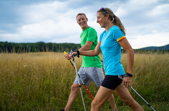 Walking for beginners - woman learns the technique from a Nordic walking trainer.