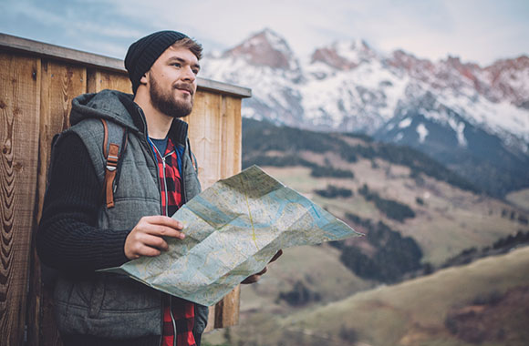 Hiker takes a break and looks at the map. Hiker takes a break and looks at the map.