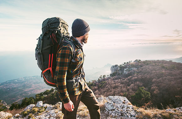 Man with hiking backpack looking into the distance.