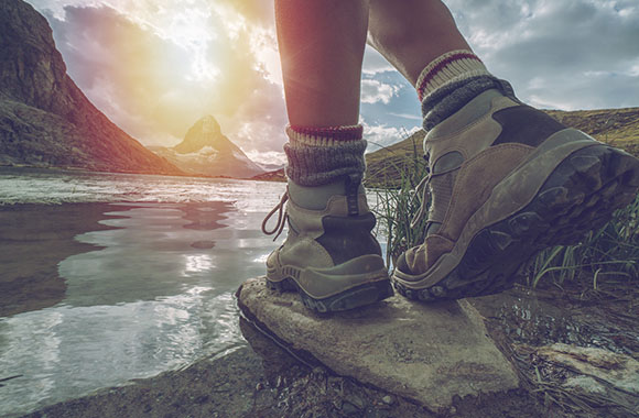 Close-up of legs of a hiker with proper hiking boots.