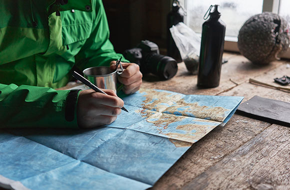 Hiker plans his hiking route with a map.