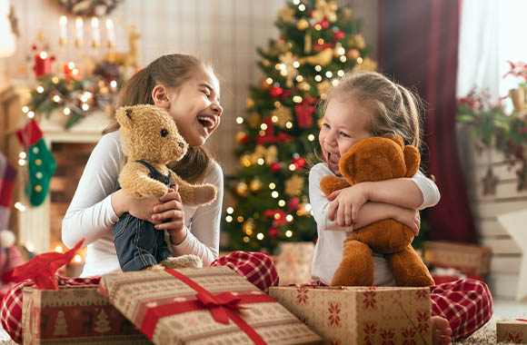 Christmas presents - two girls are excited about their new teddy bear.