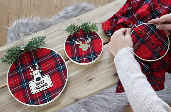 Christmas craft idea – upcycling a shirt: embroidery hoops covered with an old flannel shirt with festive tartan pattern.