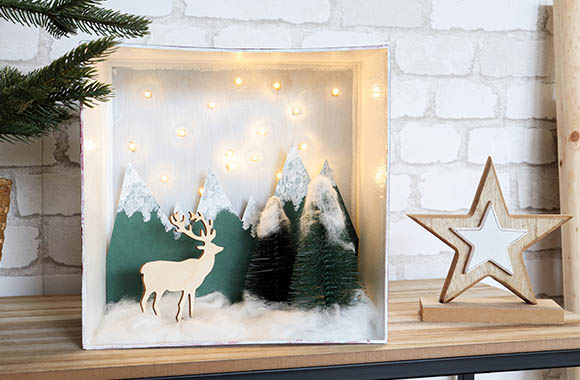 Making Christmas decorations with children: Winter landscape with a starry sky and snow-covered trees in a box.