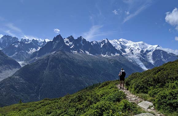 Un randonneur empruntant le sentier Tour du Mont-Blanc avec une belle vue sur les montagnes enneigées. Un randonneur empruntant le sentier Tour du Mont-Blanc avec une belle vue sur les montagnes enneigées.
