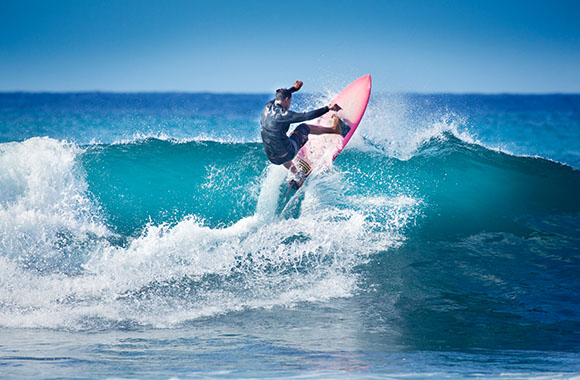 Un surfeur en train de prendre une vague.