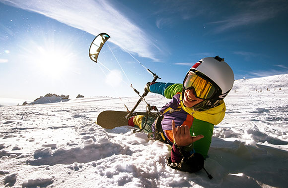 Un aficionado a los deportes de nieve practicando snow kite con una tabla de snowboard. Un aficionado a los deportes de nieve practicando snow kite con una tabla de snowboard.