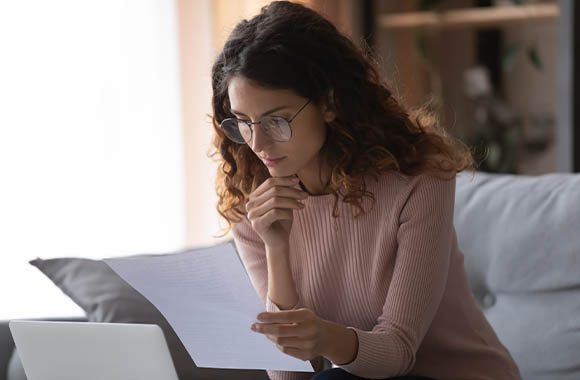 Une femme vérifie minutieusement son contrat de location. Une femme vérifie minutieusement son contrat de location.