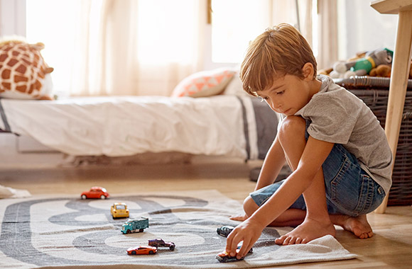 Freies Spiel Kinder – Junge spielt alleine mit Spielzeugautos. Freies Spiel Kinder – Junge spielt alleine mit Spielzeugautos.